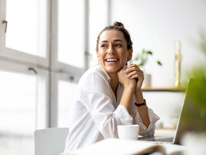 Professional female worker sitting at computer smiling